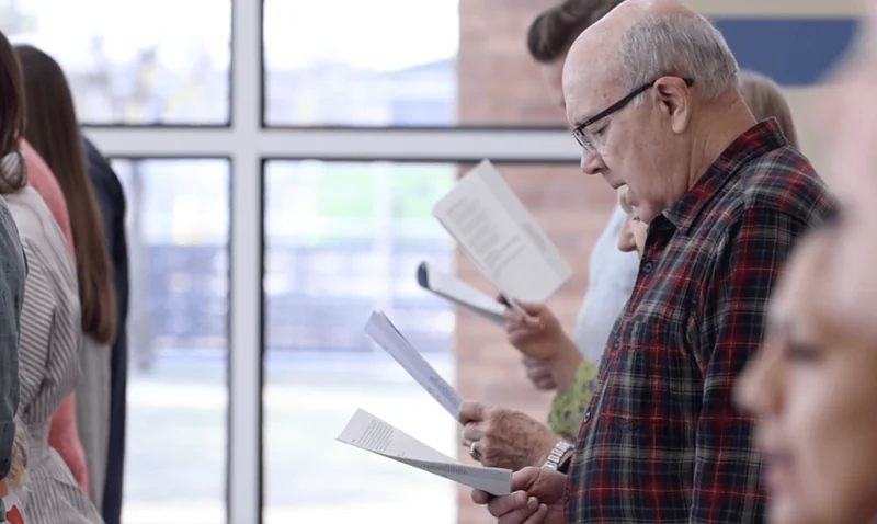 Providence congregation singing together from printed song sheets